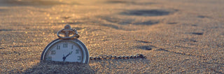 A pocket watch in the sand representing the importance of the Time Toolbox.